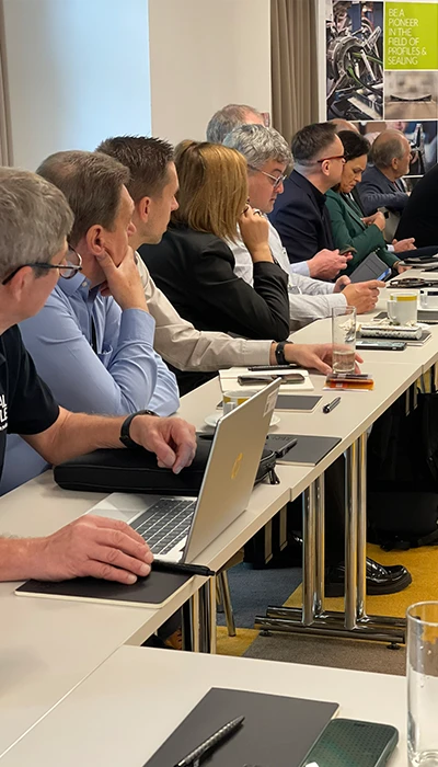 Teilnehmer zu den AgentDays sitzen an Tischen und lauschen dem Vortrag