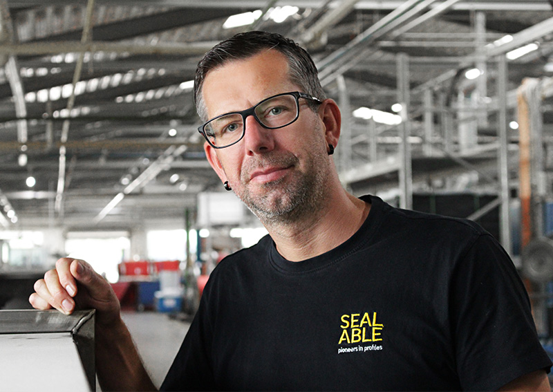 zufriedener Mitarbeiter am Arbeitsplatz in der Produktionshalle